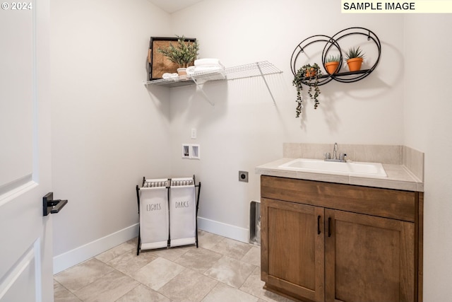 clothes washing area featuring electric dryer hookup, hookup for a washing machine, and sink