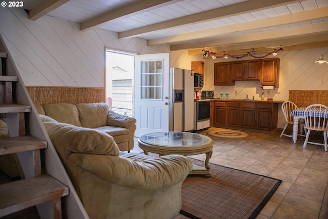 living room featuring light tile flooring, sink, and beamed ceiling