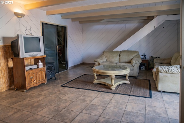 living room with beam ceiling, dark tile floors, and wood walls