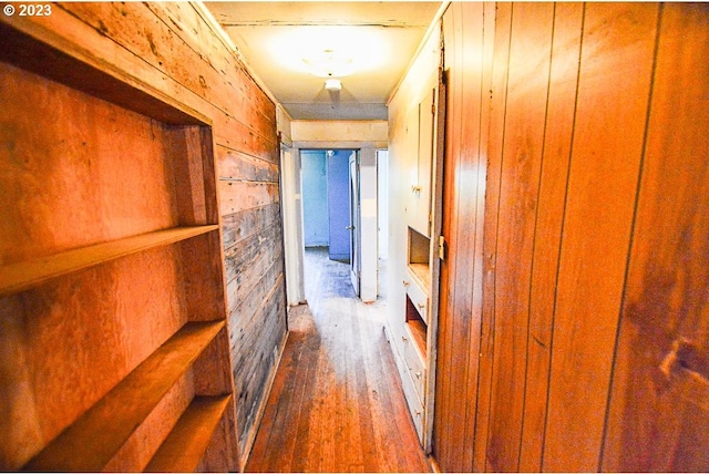 corridor featuring wooden walls and hardwood / wood-style floors