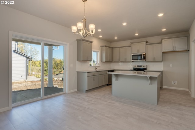 kitchen with hanging light fixtures, a notable chandelier, appliances with stainless steel finishes, and gray cabinets