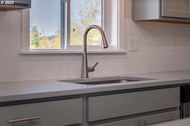 room details featuring stainless steel dishwasher, backsplash, and vanity