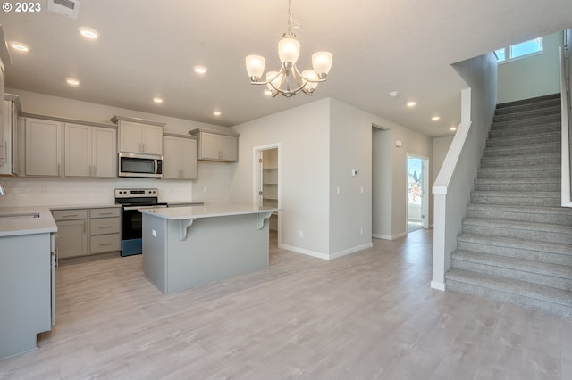 kitchen featuring a chandelier, a center island, electric range, light hardwood / wood-style flooring, and gray cabinetry