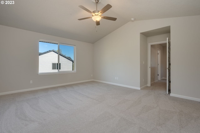 carpeted empty room with ceiling fan and vaulted ceiling