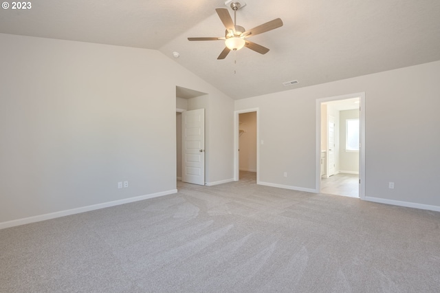 carpeted spare room featuring lofted ceiling and ceiling fan