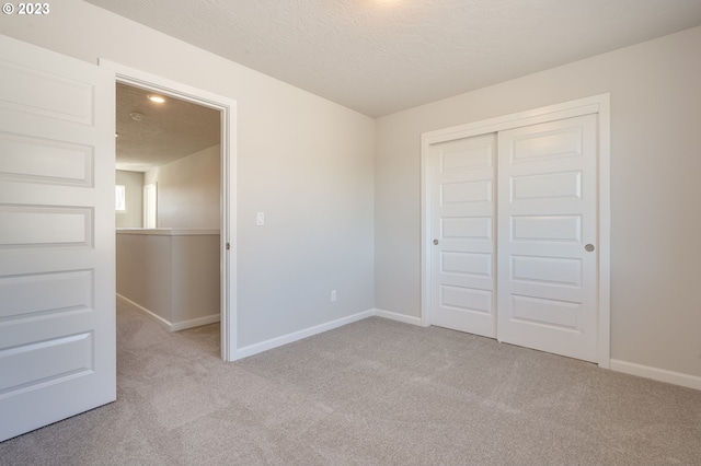 unfurnished room with a textured ceiling and light carpet