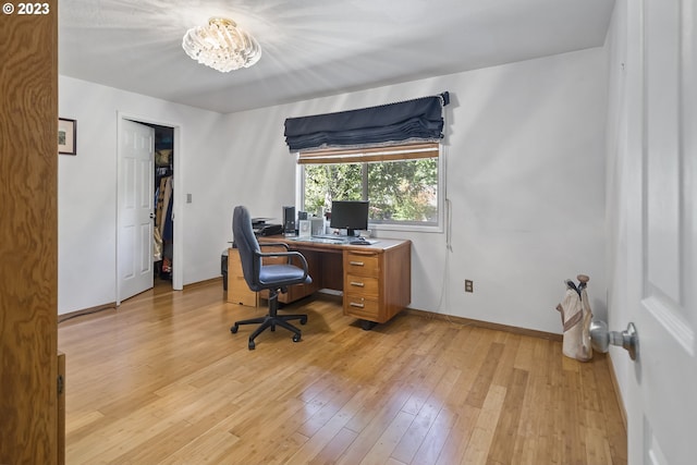 office area featuring a notable chandelier and light hardwood / wood-style floors