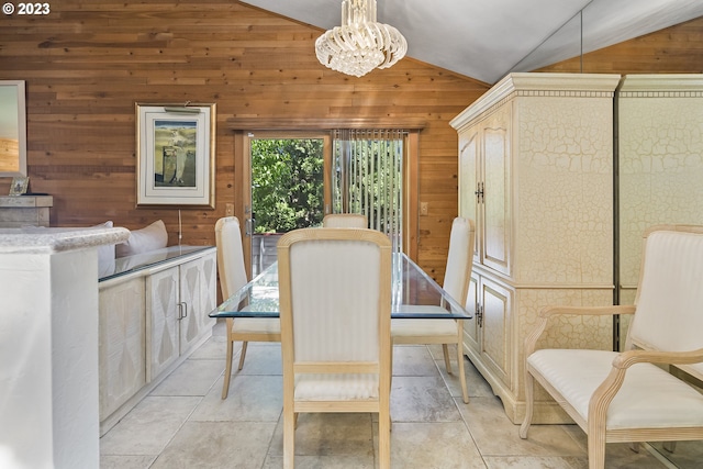 dining area featuring a chandelier, wood walls, light tile flooring, and vaulted ceiling