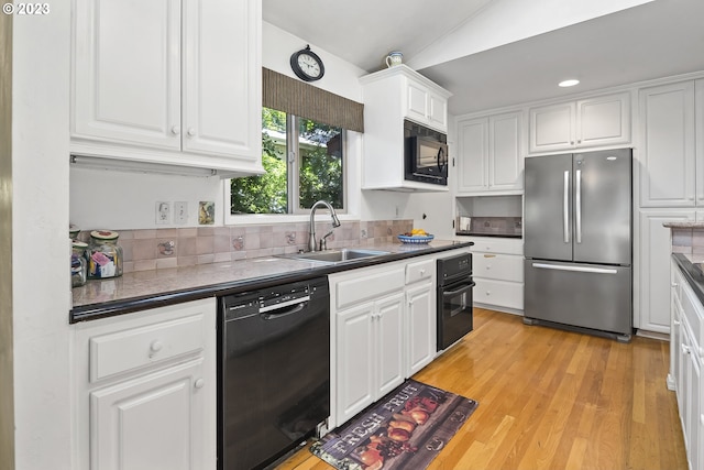 kitchen with black appliances, light hardwood / wood-style floors, sink, white cabinets, and tasteful backsplash