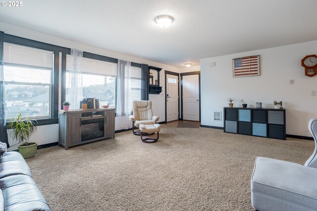 carpeted living area featuring baseboards