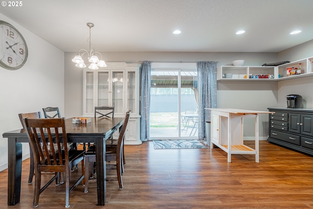 dining space with a chandelier, baseboards, wood finished floors, and recessed lighting