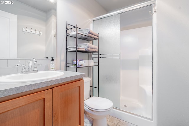 bathroom with vanity, a shower stall, toilet, and tile patterned floors