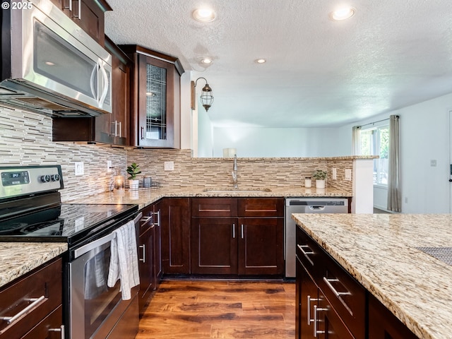 10204 NE 6th Ave, Vancouver, WA 98685 - kitchen featuring appliances with stainless steel finishes, a textured ceiling, dark wood-style floors, decorative backsplash, and light stone counters