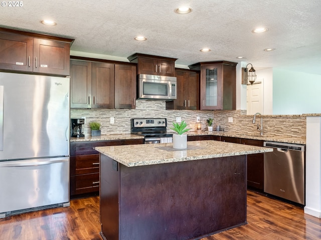 10204 NE 6th Ave, Vancouver, WA 98685 - kitchen featuring appliances with stainless steel finishes, dark brown cabinetry, dark wood-type flooring, a center island, and a textured ceiling