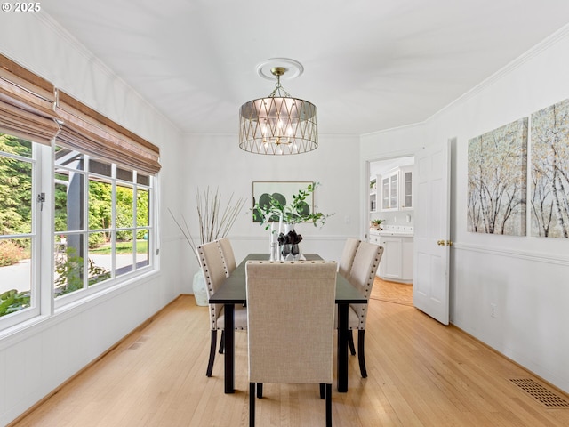 1209 Lake Garden Ct, Lake Oswego, OR 97034 - dining room featuring a chandelier, light wood finished floors, and crown molding
