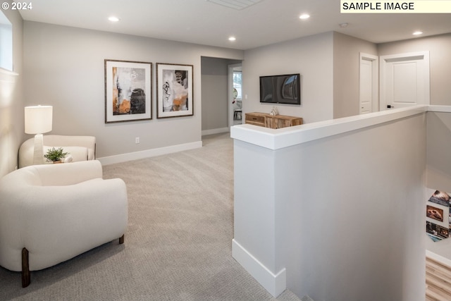 sitting room featuring light colored carpet