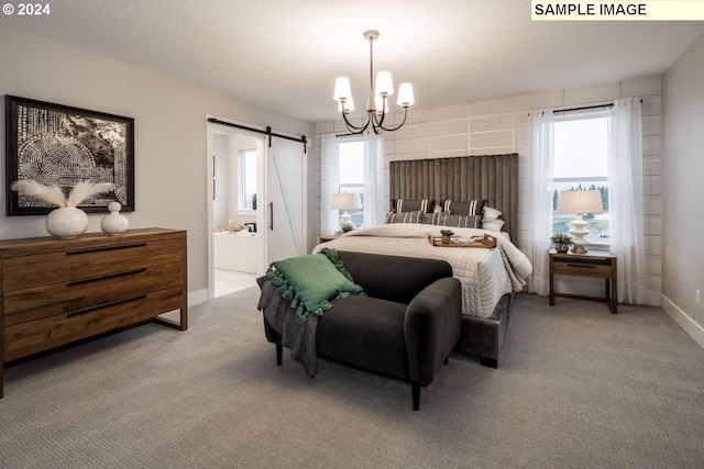 carpeted bedroom with a notable chandelier, ensuite bathroom, and a barn door