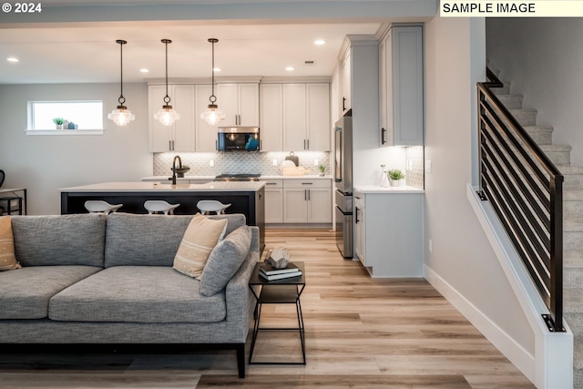 living room with sink and light hardwood / wood-style floors