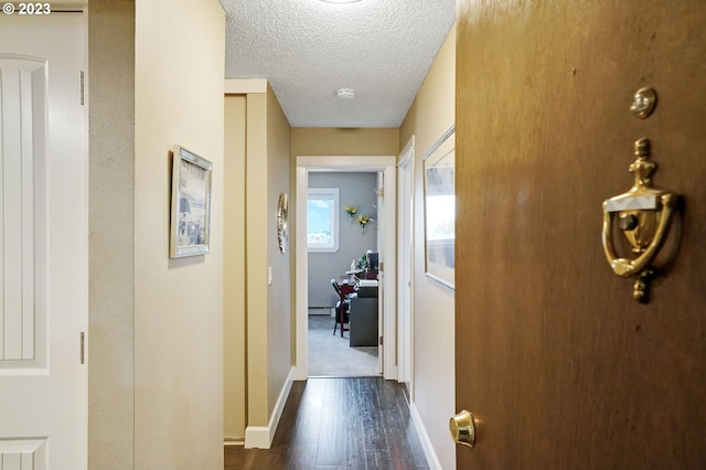 corridor with a textured ceiling, a baseboard radiator, and dark hardwood / wood-style floors