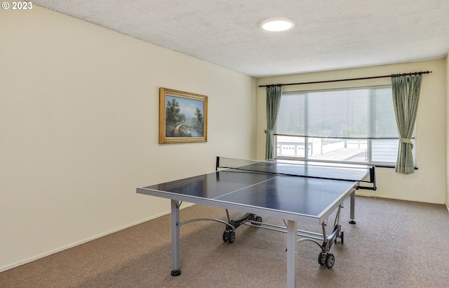 recreation room featuring dark colored carpet and a textured ceiling