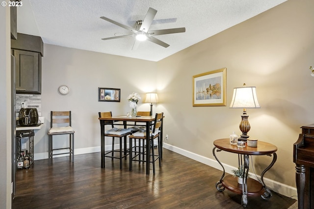 dining space featuring a ceiling fan, dark wood-style floors, baseboards, and a textured ceiling