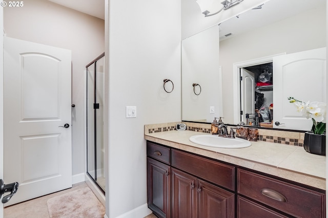 10703 NW Glenmore Way, Portland, OR 97229 - full bathroom with a shower stall, vanity, a walk in closet, and decorative backsplash