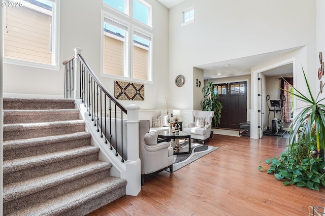10703 NW Glenmore Way, Portland, OR 97229 - living area featuring stairway, light wood-type flooring, and a towering ceiling