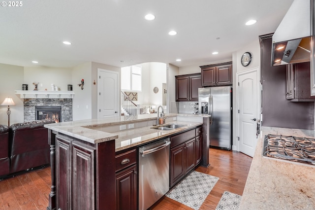 10703 NW Glenmore Way, Portland, OR 97229 - kitchen with stainless steel appliances, open floor plan, wall chimney range hood, light wood-style flooring, and recessed lighting