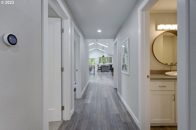 hallway featuring vaulted ceiling and hardwood / wood-style flooring