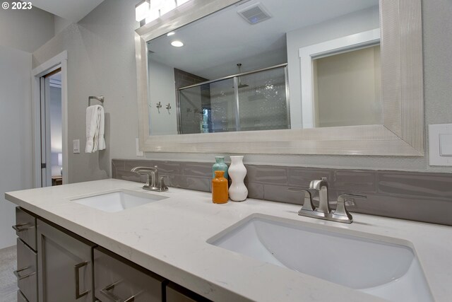 bathroom featuring backsplash and double sink vanity