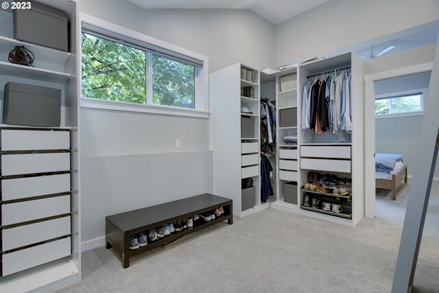 spacious closet with light colored carpet and vaulted ceiling