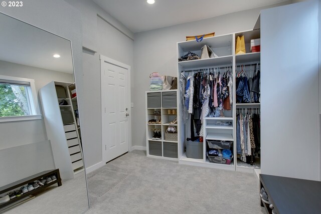 walk in closet featuring light colored carpet