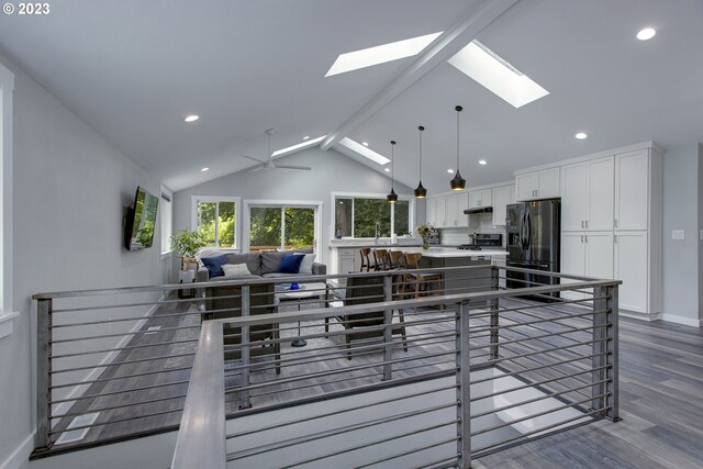 kitchen with dark hardwood / wood-style flooring, white cabinets, beamed ceiling, decorative light fixtures, and stainless steel refrigerator with ice dispenser