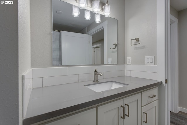 bathroom with backsplash, hardwood / wood-style flooring, and vanity