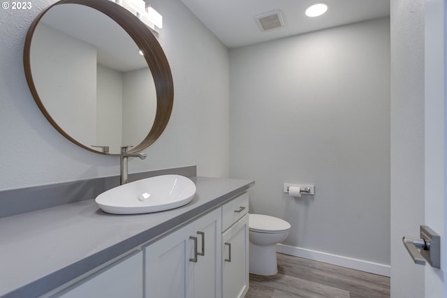 bathroom featuring toilet, large vanity, and hardwood / wood-style floors