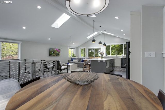 dining space featuring a skylight, high vaulted ceiling, dark hardwood / wood-style floors, and beam ceiling