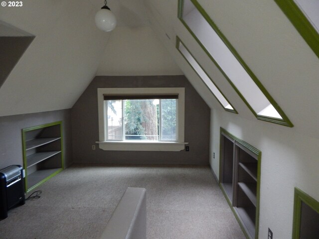 additional living space with light carpet and vaulted ceiling with skylight