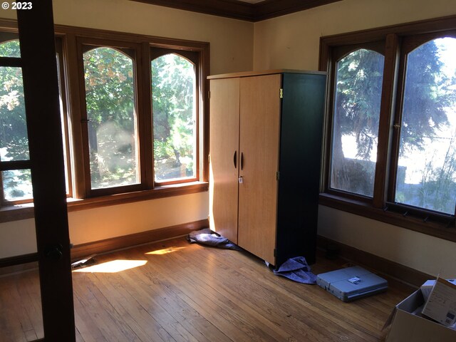 exercise room featuring ornamental molding and dark wood-type flooring