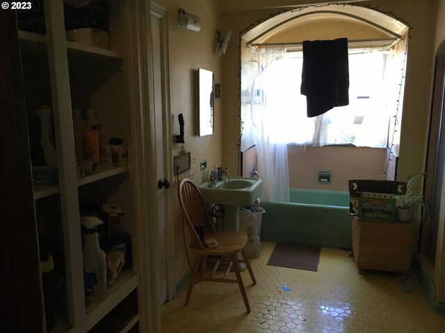 misc room featuring light tile flooring, sink, and a wealth of natural light