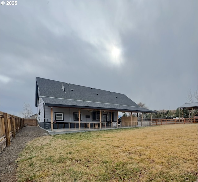 rear view of house featuring a yard, a patio, a fenced backyard, and a shingled roof