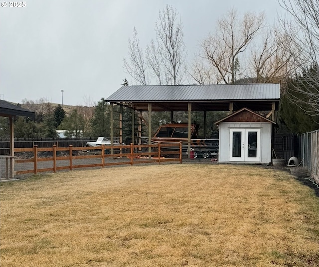 view of property's community featuring an outbuilding, a lawn, and fence