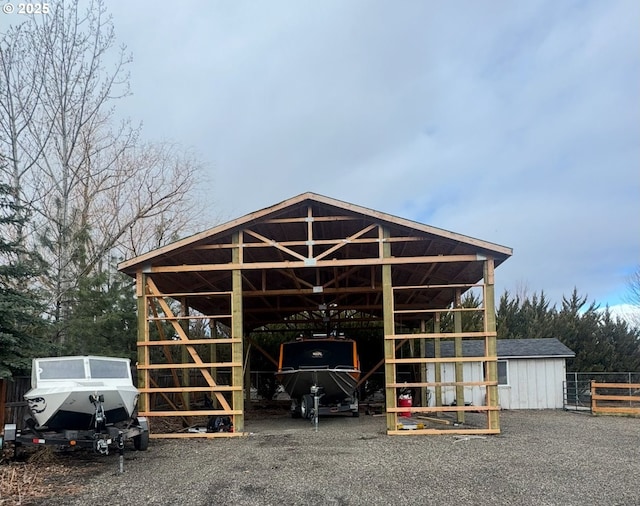 view of outdoor structure with a detached carport, an outdoor structure, and fence