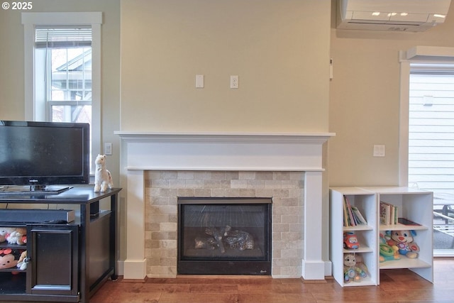 room details featuring wood finished floors, a fireplace, and a wall mounted AC