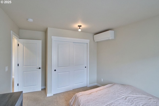 carpeted bedroom with baseboards, a closet, and a wall mounted AC