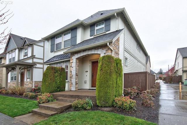 view of front of home featuring stone siding, stucco siding, metal roof, and a residential view