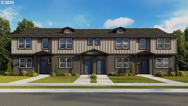 multi unit property with board and batten siding and a front lawn