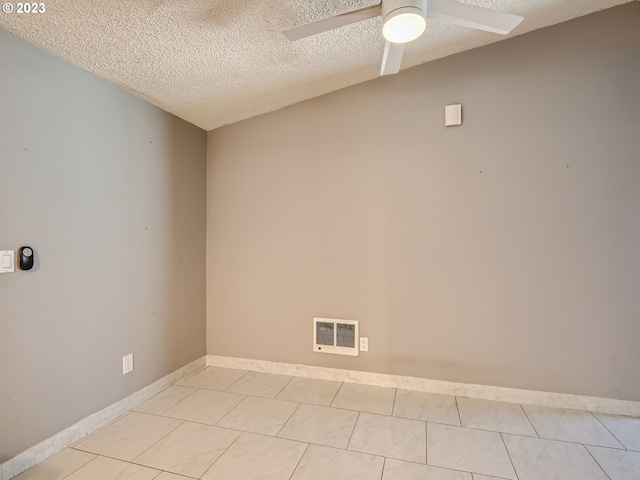 unfurnished room with ceiling fan, light tile floors, and a textured ceiling