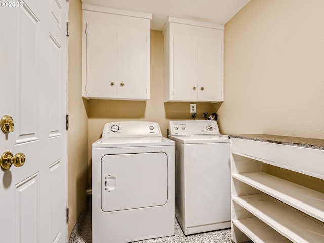 washroom with cabinets and washing machine and dryer