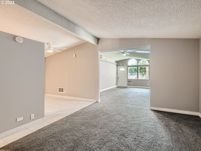 spare room with lofted ceiling with beams, a textured ceiling, light colored carpet, and ceiling fan