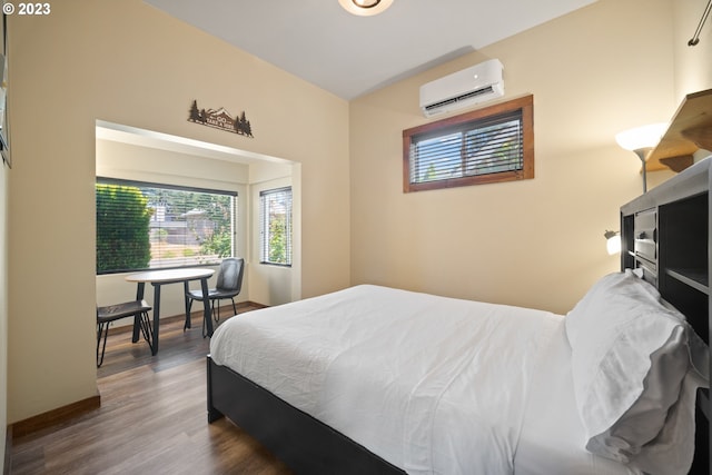 bedroom with a wall mounted AC and dark wood-type flooring